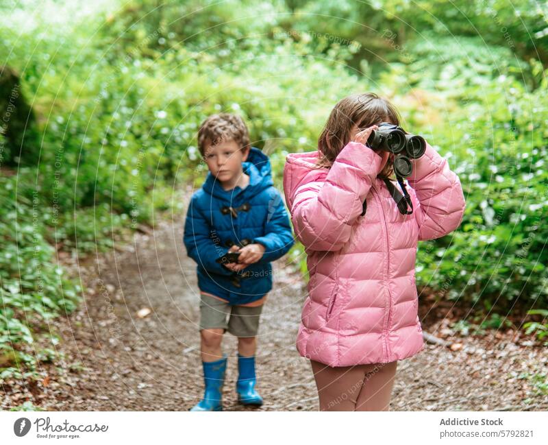 Enkelkinder erkunden die Natur mit Fernglas und Kompass Erkundung Spaziergang im Freien Freizeit Familie Erfahrung Kinder Junge Mädchen Jacke rosa blau Stiefel
