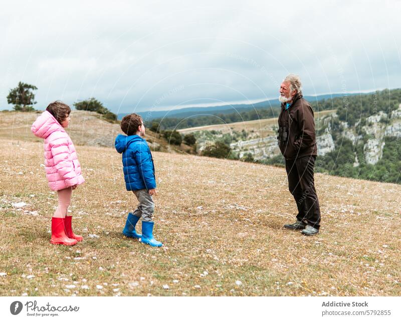 Großvater mit Enkelkindern, die gemeinsam die Natur genießen Junge Mädchen Familie Freizeit im Freien Hügel grasbewachsen Bonden Freude Feld malerisch Ansicht