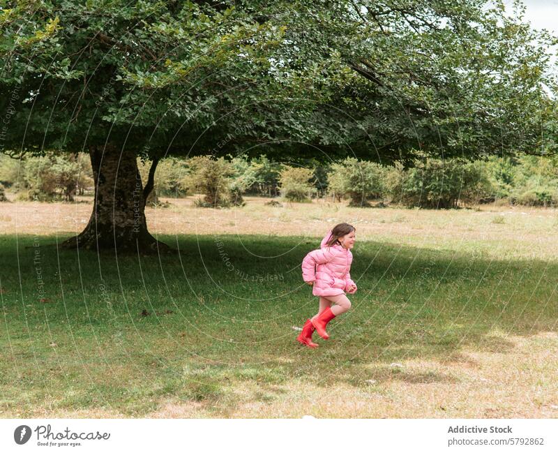 Enkelin rennt freudig in einem Park Mädchen Kind rennen Spaß im Freien Freizeit Familie Baum Freude jugendlich Aktivität spielen energetisch Natur Gras lässig