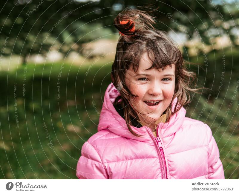Lächelndes Mädchen in rosa Jacke genießt Familienzeit im Freien Freizeit Porträt Frisur Freude Fröhlichkeit Kind Spaß Ausdruck spielerisch Natur Park Kindheit