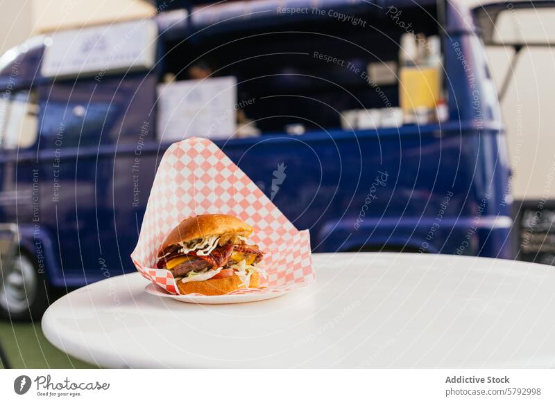 Gourmet-Burger, serviert in einem lebhaften Foodtruck Imbisswagen Feinschmecker Straßenessen Tischplatte blau kariertes Papier Servieren lecker Fastfood