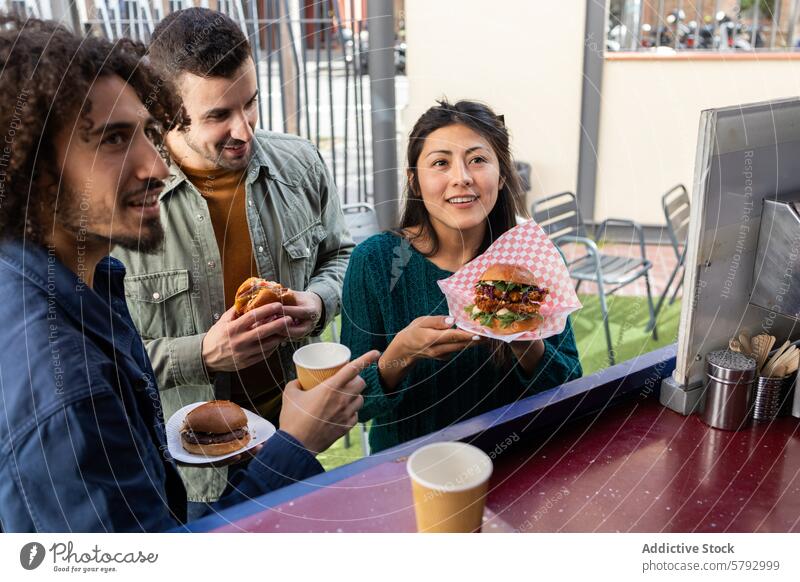 Eine Gruppe von Freunden genießt das Essen in einem Imbisswagen Straßenessen Feinschmecker urban Lifestyle Freude Teilen Moment diverse Gruppe Frau Burger