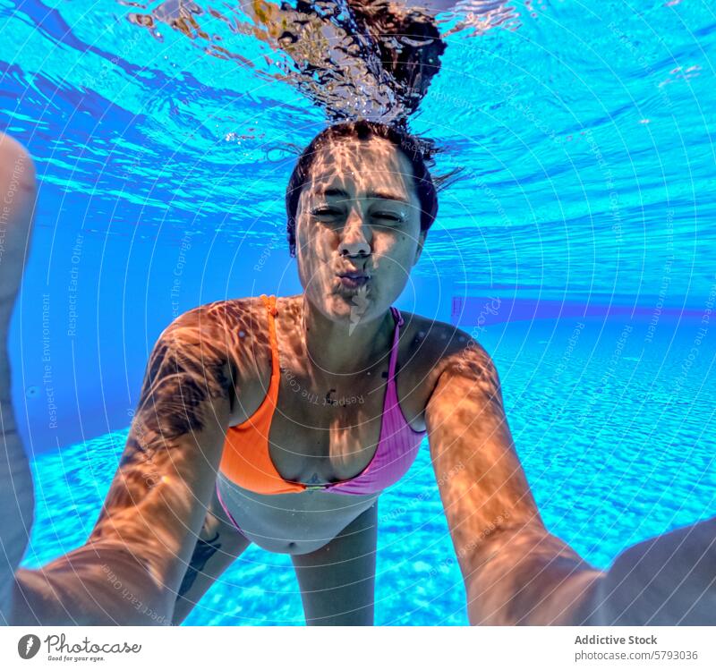 Frau genießt Unterwasser-Selfie in sonnigen Pool unter Wasser Schwimmsport Sommer Sonne blau spielerisch Spaß Badebekleidung Bikini Freizeit aquatisch Urlaub