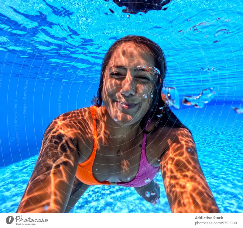 Unterwasserspaß mit einer lächelnden Frau beim Schwimmen am Strand unter Wasser Schwimmsport Spaß sonnig Lichtmuster heiter schwimmen blau Meer MEER Sommer