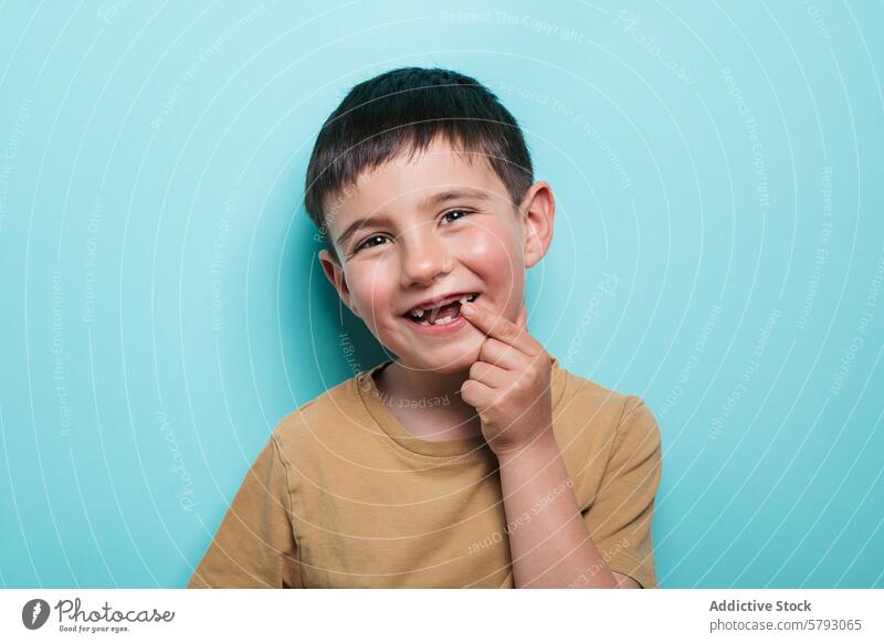 Fröhlicher Junge zeigt seinen fehlenden Zahn Kind Lächeln zahnlos Porträt Atelier Glück Blauer Hintergrund fehlender Zahn heiter Freude Jugend Unschuld