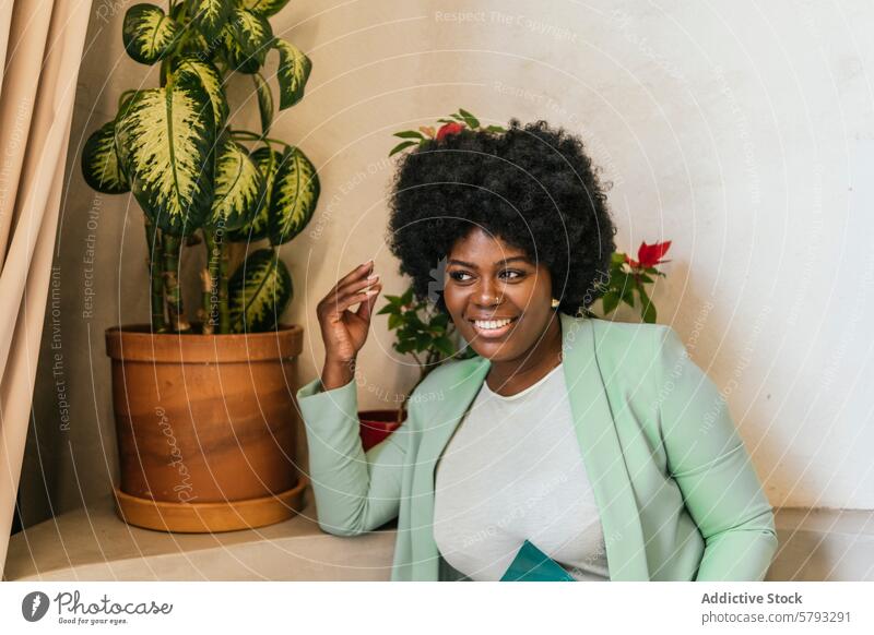 Berufstätige Frau, die eine Pause in einem Coworking Space genießt Raum Afroamerikaner Lächeln modern Topfpflanze Sitzen professionell Glück strahlend