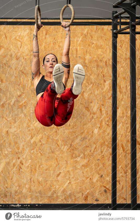 Frau macht Kernübungen mit olympischem Ring in einem Fitnessstudio vertikal reif sportlich Kerngehäuse olympischer Ring Übung Textfreiraum aktiver Lebensstil