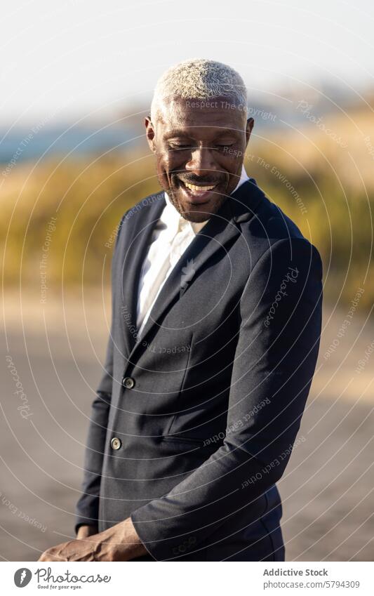 Eleganter afroamerikanischer Mann posiert am Strand Afroamerikaner Stil Mode Anzug Lächeln Eleganz Model männlich schwarz im Freien sandig flott charmant