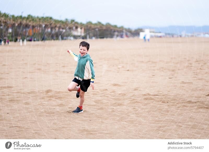 Junge spielt fröhlich am Strand im Sommer Kind spielen Sand Glück Freude Urlaub Freizeit im Freien Palme Küste Seeküste Meer MEER Spaß Lächeln jung Jugend