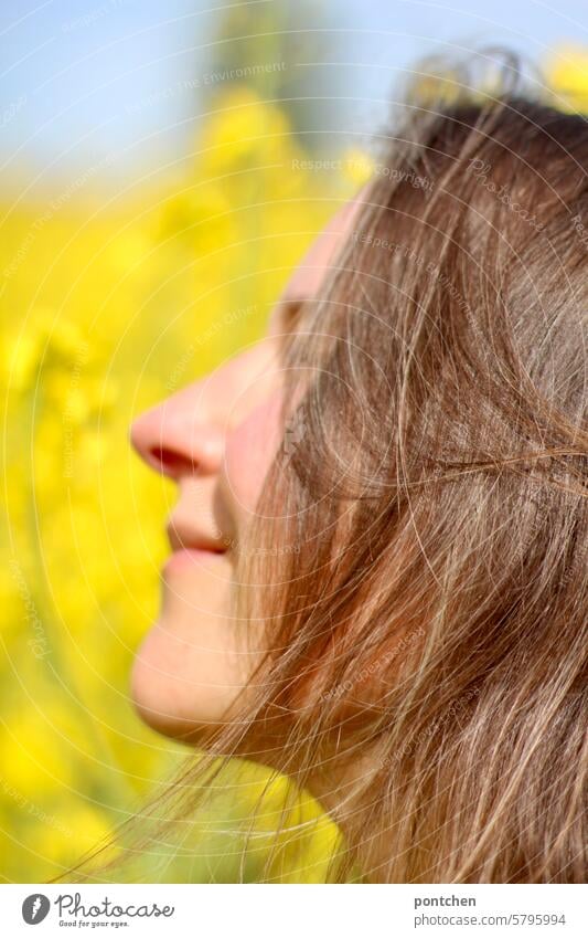 Gesicht einer lächelnden Frau im Profil im Rapsfeld raps rapsfeld landwirtschaft ökologische landwirtschaft gelb anbau pflanzen Nutzpflanze Rapsblüte Frühling