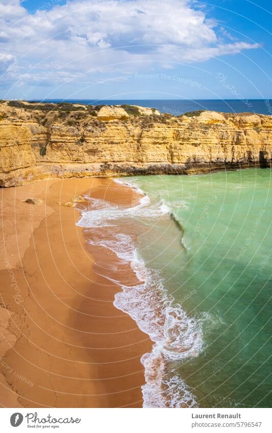 Vertikaler Blick auf Klippen und Meereswellen, die auf den Strand in der Nähe von Albufeira, Portugal, prallen Antenne Algarve atlantisch Küste
