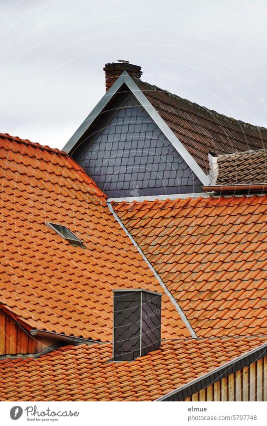verschachtelte Ziegeldächer mit Dachfenster und Schornsteinen, Hausgiebel mit Schiefer Ziegeldach Dachziegel Giebel Strukturen & Formen rot Tonschiefer wohnen