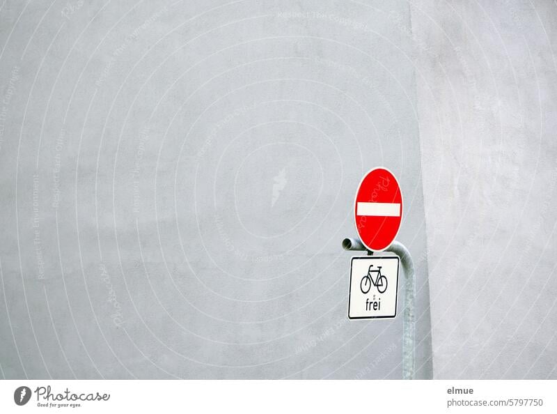 Verkehrszeichen - Verbot der Einfahrt - und Zusatzschild - Radfahrer frei - an einer Metallstange vor einem Gebäude Verkehrsschild VZ 267 Zusatzzeichen