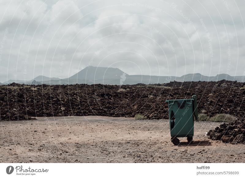 Müllbehälter vor einem erkalteten Lavafeld mit Vulkankegeln im Hintergrund Müllentsorgung erkaltete Lava Natur Landschaft Außenaufnahme vulkanisch Lanzarote
