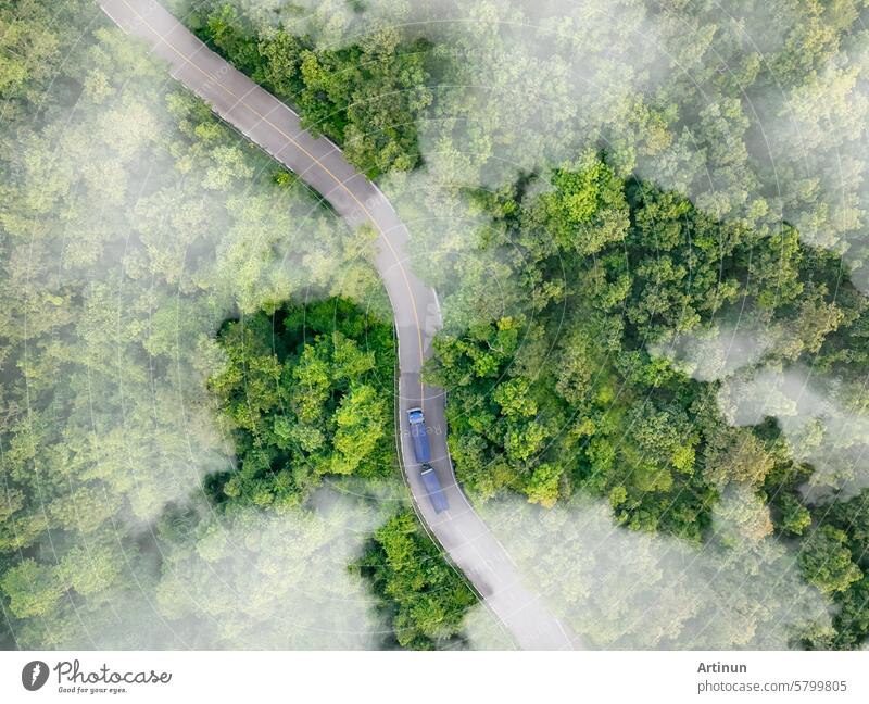 Luftaufnahme eines Wasserstoff-Energie-Lkw, der auf einer Autobahn in einem grünen Wald fährt. Nachhaltiger Transport. Blauer Lkw fährt auf Asphaltstraße im Wald. Wasserstoff-Brennstoffzellen-Fahrzeug. Null-Emissions-Auto.