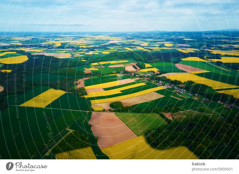 Luftaufnahme einer Landschaft mit blühendem Raps auf landwirtschaftlichen Feldern Bereiche Feldfrüchte ländlich Ackerland Farben grün gelb kontrastierend