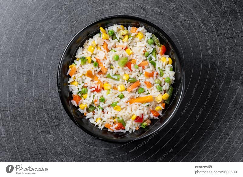 Weißer Reis mit Gemüse in einer schwarzen Schale auf einem Holztisch Schalen & Schüsseln Möhre Kichererbsen Mais Diät Speise Lebensmittel grüne Bohnen