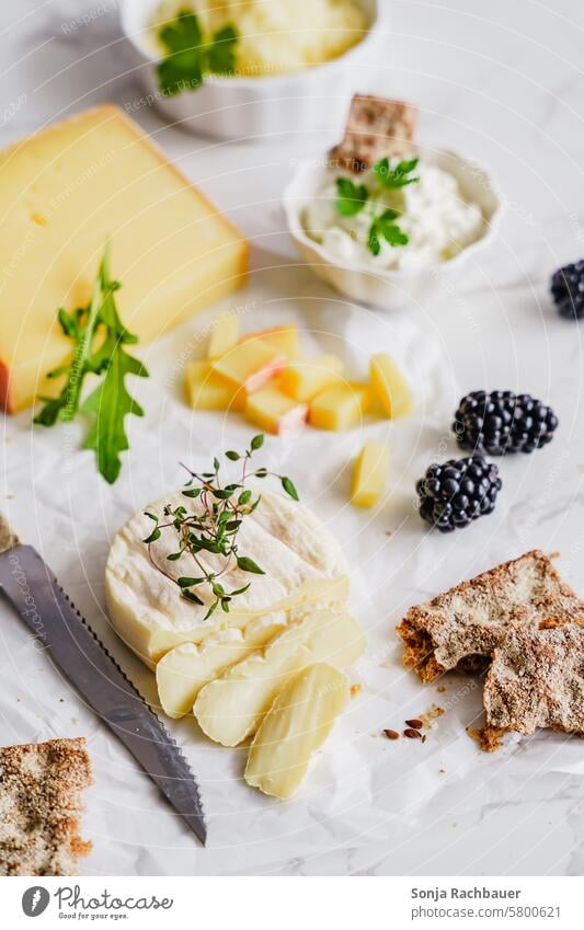 Verschiedene Käsesorten und Knäckebrot auf einem weißen Papier Frühstück Vegetarische Ernährung Bioprodukte Lebensmittel Protein lecker Farbfoto Brot