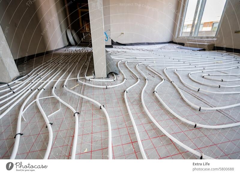 Rohrsystem einer Fußbodenheizung in einem im Bau befindlichen Wohngebäude quer ausrichten einstellbar Zusammengebaut Wegbiegung Tiefbau Klima komplex