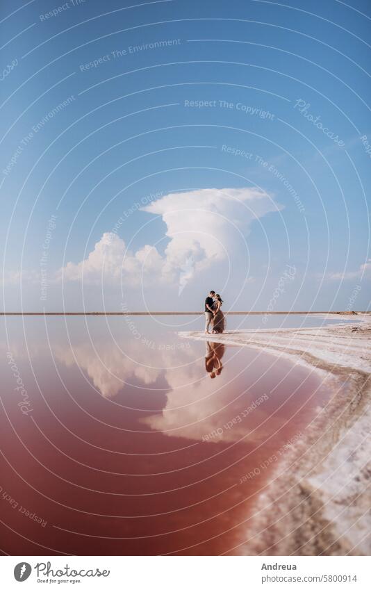 Mädchen und ein Mann am Ufer eines rosa Salzsees jung Paar See stehen Reflexion & Spiegelung Stil Zusammensein Strand MEER Fluss weiß Fliederbusch Himmel Licht