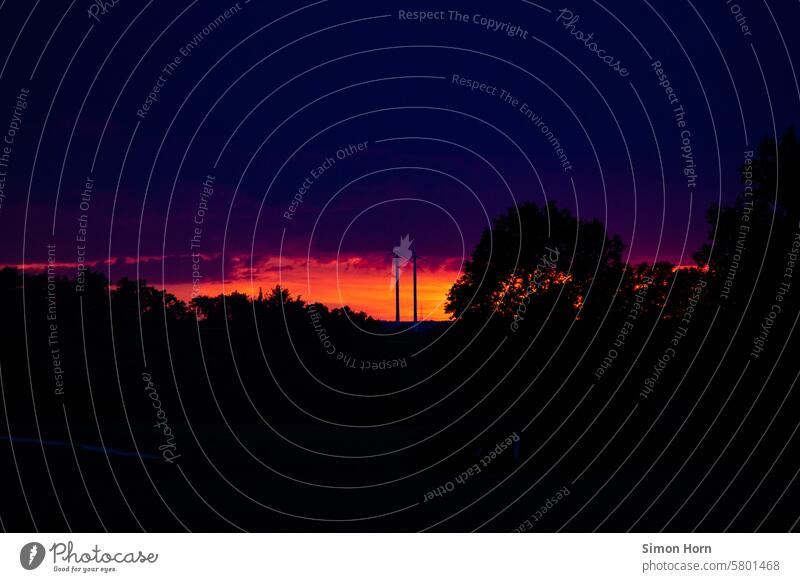 Sonnenuntergang mit intensiven Farben, Windrädern und großer Baumkrone Abendrot Landschaft Himmel Firmament Dämmerung Abenddämmerung Horizont Wolken Lichtstreif