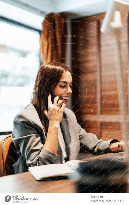 Frau, die in einem Büro arbeitet und telefoniert Smartphone Aufruf Geschäftsfrau Business sprechend Mobile Anruf Telefon reden arbeiten Handy Laptop Funktelefon