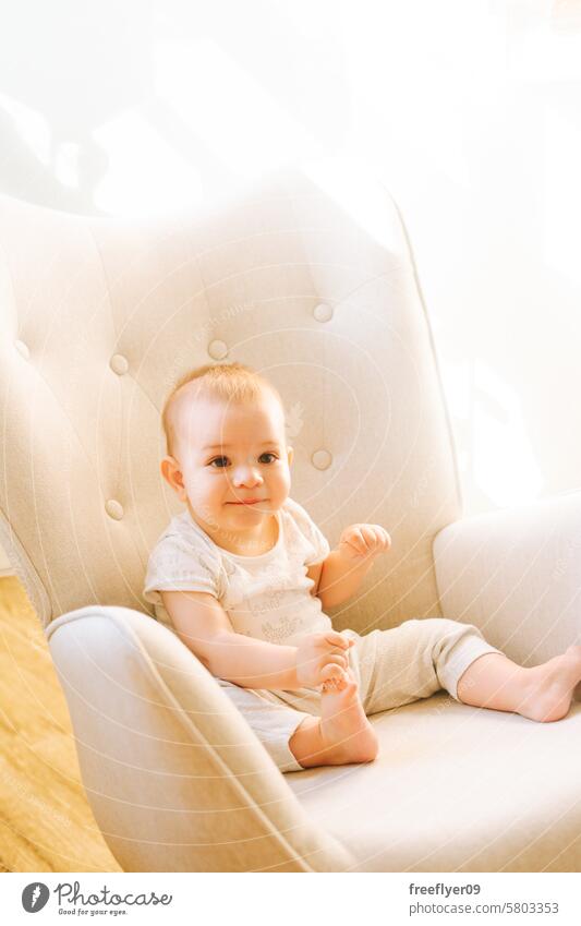 Porträt eines neun Monate alten Babys, das in einem Schaukelstuhl sitzt Kleinkind Sitzen Stuhl Tierpräparat Textfreiraum bezaubernd Elternschaft Mutterschaft
