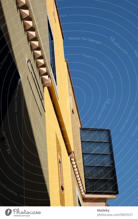Geometrische architektonische Akzente in einer modernen Fassade in Gelb und Beige vor blauem Himmel bei Sonnenschein als Teil der Goethehöfe am Großen Hirschgraben in der Innenstadt von Frankfurt am Main in Hessen