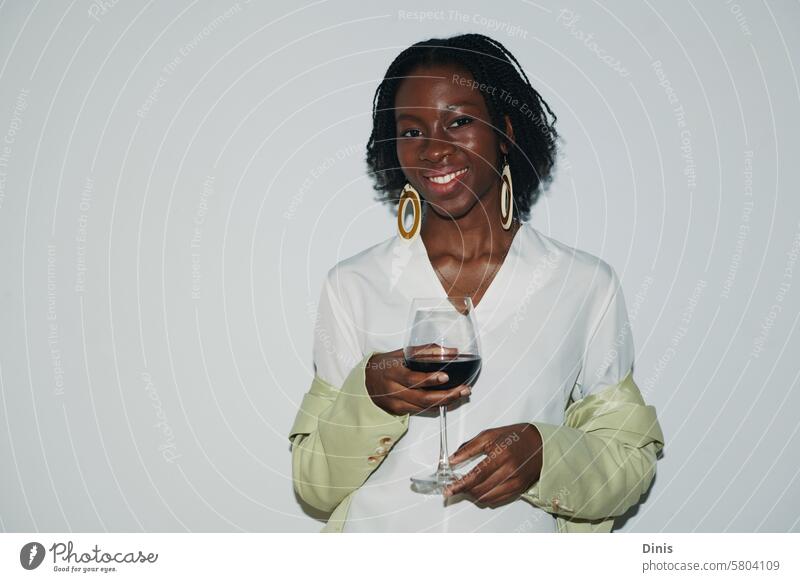 Portrait of smiling Black woman with glass of red wine drink party portrait office celebrate friday businesswoman workplace alcohol positive smile flash excited