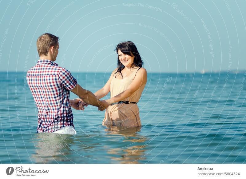 ein Mann und ein Mädchen gehen am Meer entlang Typ an der Küste MEER Spaziergang Wasser Freude Lächeln Zusammensein blau Himmel Strand Sand Liebe Paar Sommer