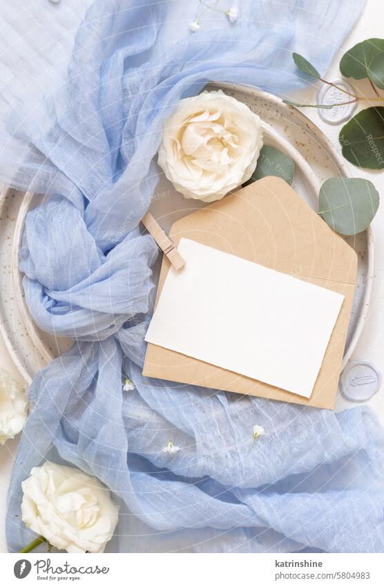 Karte und Umschlag in der Nähe von blauen Tüll Stoff und Creme Rosen Draufsicht kopieren Raum, Hochzeit Mockup Attrappe Kuvert Postkarte romantisch Sahne Blumen