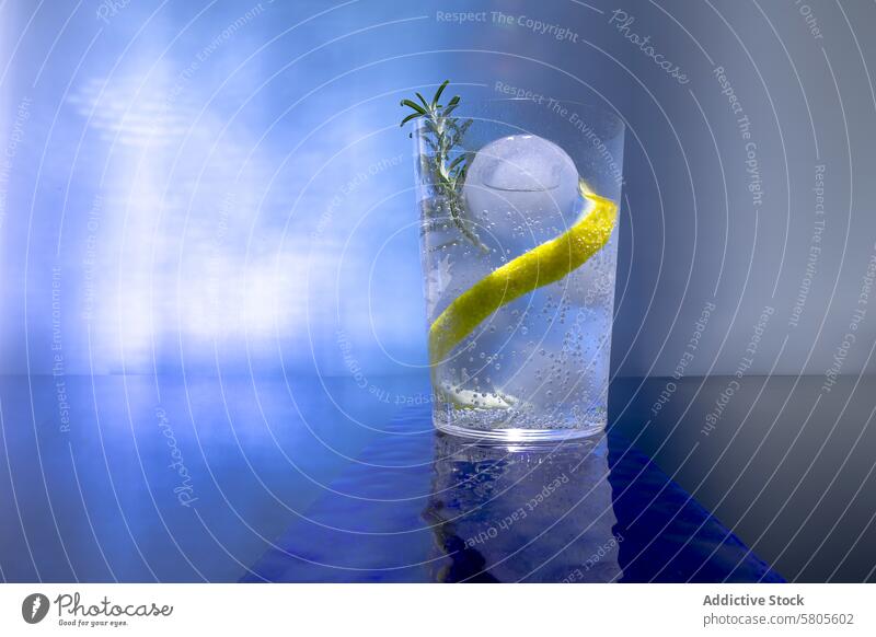 Gin-Tonic-Cocktail mit Eis und Zitrone auf Blau trinken Getränk Alkohol erfrischend Kugel sich[Akk] schälen Garnierung Glas blau Hintergrund sprudelnd kalt Bar