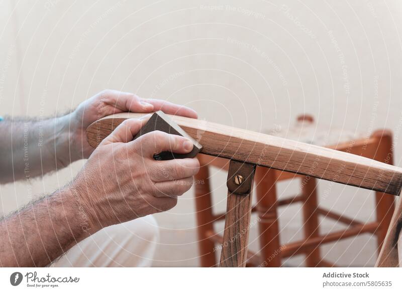Handwerker Schleifen Holzstuhl für die Restaurierung Handwerkskunst hölzern Stuhl Restauration Möbel Lackierung Oberfläche Vorbereitung Projekt Holzarbeiten