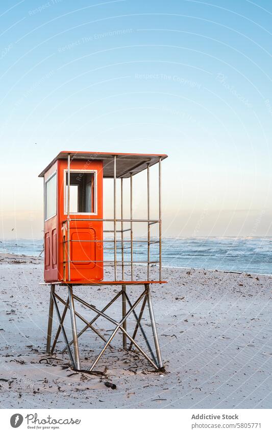 Rettungsschwimmerturm an einem Sandstrand bei Sonnenaufgang Rettungsschwimmturm Strand Meer Wellen Klarer Himmel ruhig Meereslandschaft Küstenlinie Sicherheit