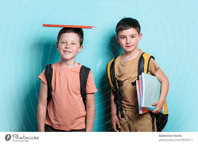 Schuljungen mit Büchern und Rucksäcken bereit für den Unterricht Schule Junge Rucksack Lächeln Fotokamera blaugrün Hintergrund Buch Kopf Stehen Bildung Kind