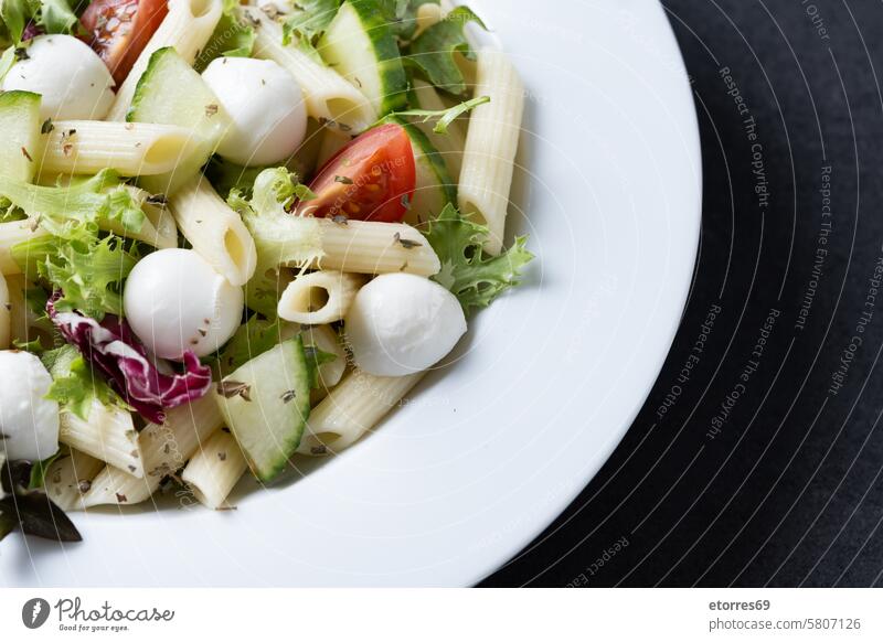 Nudelsalat mit Gemüse und Mozzarellakäse auf schwarzem Hintergrund Salatgurke Speise Gesundheit Bestandteil Makkaroni Mahlzeit Mozzarellakugel Ernährung Spätzle