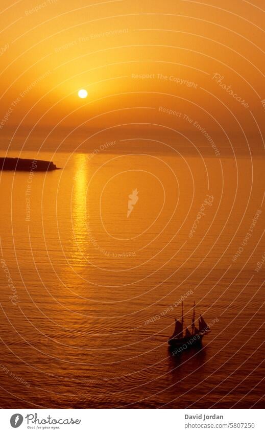 orange goldener Sonnenuntergang mit Segelschiff im Mittelmeer Segelschiff vor Sonnenuntergang Griechenland Santorini