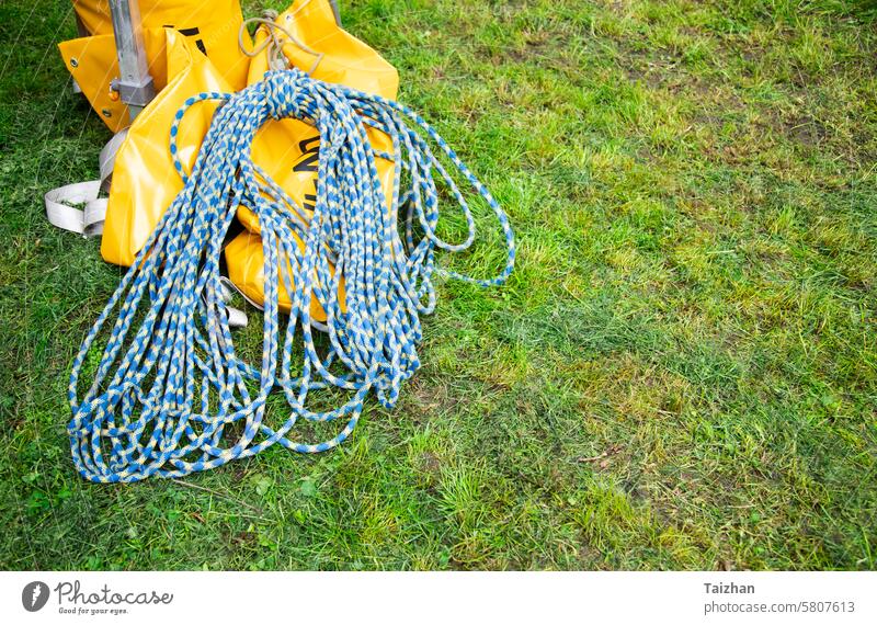 Blaues Kletterseil auf grünem Gras.  Hintergrundbild des Seils für aktive Sportarten. Raum kopieren abstrakt Aktivität Erwachsener Abenteuer blau Geflecht Kabel