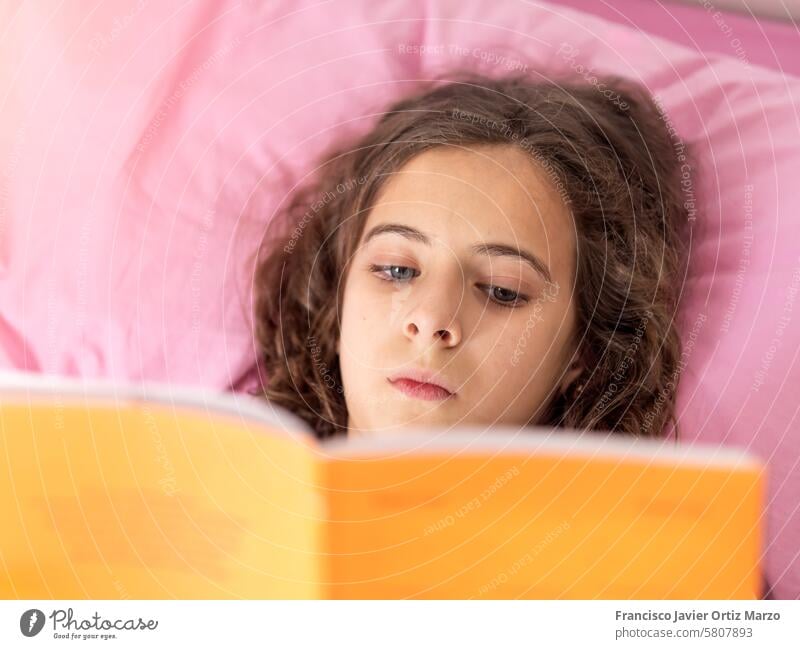 Junges Mädchen liest Buch in rosa Bett jung lesen Komfort sich[Akk] entspannen heimwärts Freizeit Bildung Literatur Jugend Schlafzimmer gemütlich Lernen lernen