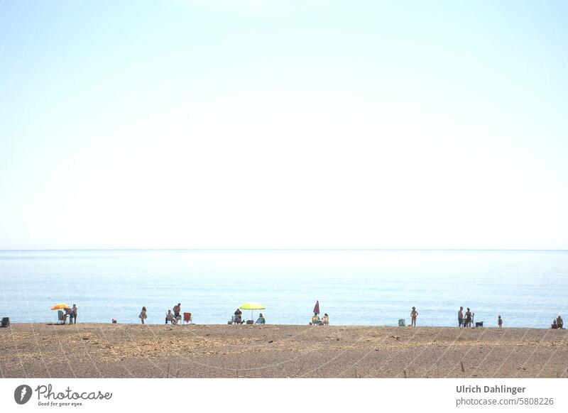 Menschen am Strand vor ruhigem Meer und blauem Himmel Urlaub Reise Tourismus Ferien Erholung Küste Natur