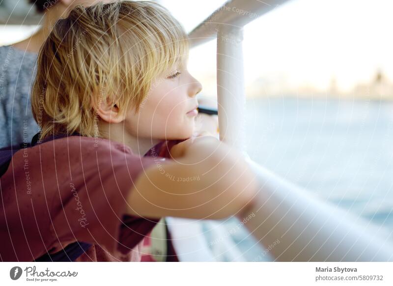 Nette blonde preteen Tourist Junge reist mit dem Boot oder Fähre auf dem Meer. Familienurlaub am Ozean oder Meer. Sommerfreizeit für Familien mit Kindern. MEER