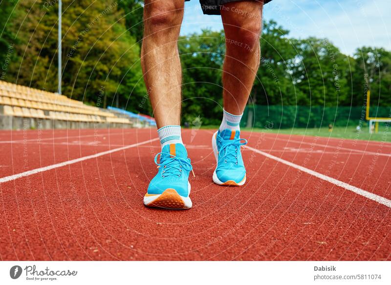 Sportler mit hellblauen Laufschuhen auf roter Stadionbahn beim Training rennen Schuhe Bahn Übung sportlich Turnschuh Beine Athlet Sprinten Joggen Fitness Paar