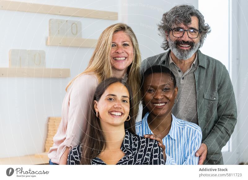 Fröhliche, vielseitige Coworking-Frauen schauen in die Kamera Kollege Arbeitsplatz Porträt Mitarbeiterin heiter Arbeitsbereich Zusammensein Lächeln Unternehmen