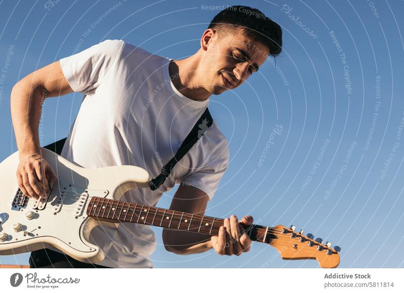 Mann spielt elektrische Gitarre auf einem blauen Himmel Hintergrund Musiker Gitarrenspieler Musical Felsen Instrument spielen Spieler Person Klang Gesang