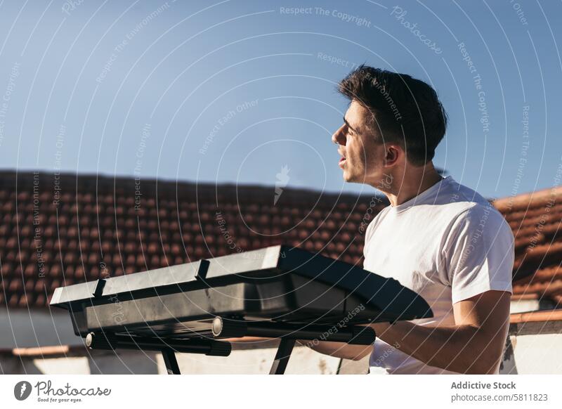 Mann spielt ein Musik-Keyboard und singt auf einem Dach Musiker Instrument Gesang Sänger Menschen Gitarre jung Konzert Lifestyle Mikrofon Band Klang Felsen