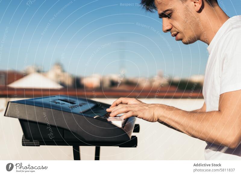 Mann spielt Klavier auf einem städtischen Dach Instrument Musik Dachterrasse Großstadt Person schwarz spielen im Freien Musiker Klang Pianist Taste weiß Spieler