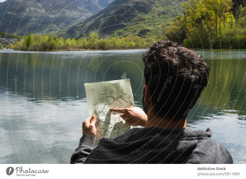 Reisender Mann liest Karte in der Nähe eines Sees im Hochland lesen Landkarte navigieren sich orientieren Berge u. Gebirge Suche reisen männlich Pyrenäen