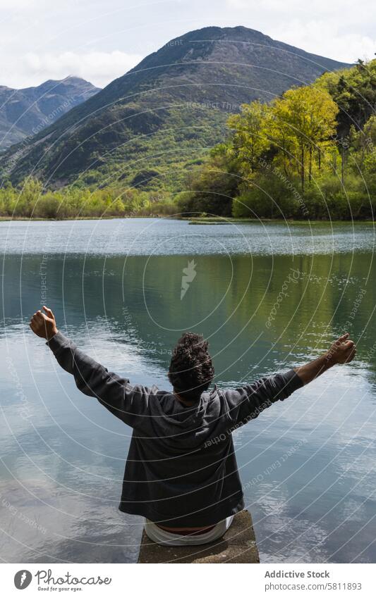 Sorglos reisender Mann genießt die Freiheit in der Nähe eines Sees in den Bergen Reisender genießen sorgenfrei ausdehnen Berge u. Gebirge Hochland Teich