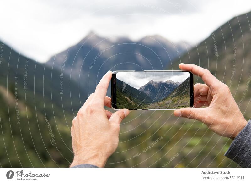 Crop-Reisender, der mit seinem Smartphone ein Foto von den Bergen macht fotografieren Berge u. Gebirge Hochland Wanderer Mob