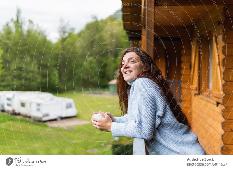 Fröhliche Frau auf der Terrasse eines Hauses in den Bergen Berge u. Gebirge Reisender Hochland trinken genießen vacat